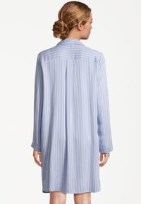 Jasnoniebieska koszula z długim rękawem w białe pionowe paski, z kołnierzykiem i detalem na plecach, wykonana z gładkiego materiału.