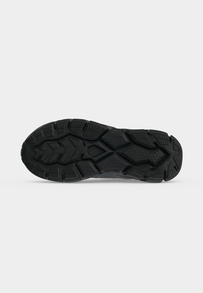 Semelle de chaussure en caoutchouc noir avec des sculptures détaillées comprenant des motifs géométriques et en nid d'abeille pour la traction et la durabilité.