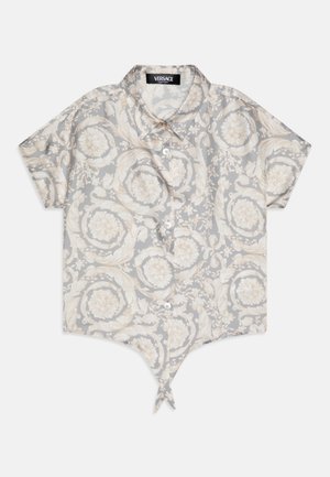 Rövid ujjú, világosszürke gombos ing, díszes, krémszínű virágmintával. Jellemzője a hegyes alsó rész és a nyakkendő részlet az alján.