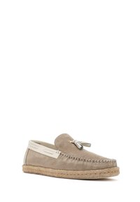 Zamszowe loafers w kolorze taupe z kremowym skórzanym akcentem. Posiadają plecioną jutikową podeszwę i kokardkę z przodu, z kontrastującym stębnowaniem.