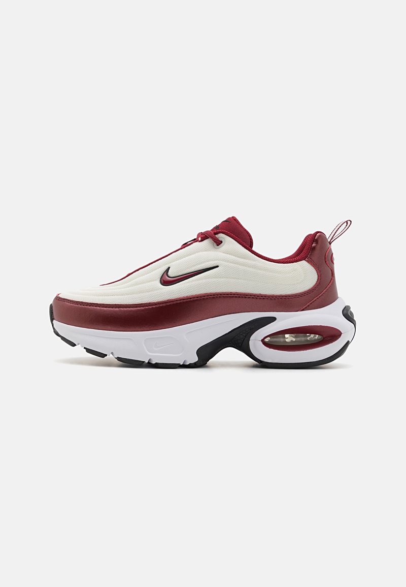 Baskets athlétiques blanches et bordeaux avec un logo swoosh noir, une semelle à coussin d'air visible et une languette à l'arrière, vues de profil.