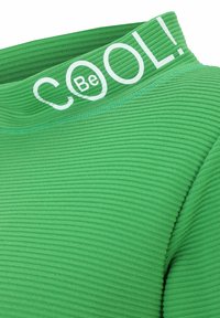 Grüner gerippter Stoffturtleneck mit breitem Kragen, auf dem "Be COOL!" in weißem Text steht. Verfügt über ein strukturiertes Muster und kontrastierende blaue Nähte.