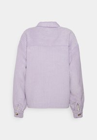 Lila kordurová bunda s ryhovanou texturou, má límec a elastické manžety s knoflíkovými detaily. Jednoduchý, volný design.