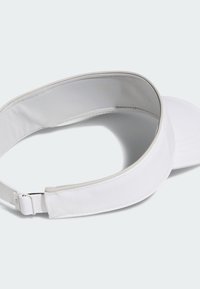 Λευκός γείσος με καμπυλωμένο γείσο, κατασκευασμένο από ελαφρύ ύφασμα. Διαθέτει ρυθμιζόμενο λουράκι και υφασμάτινη επένδυση στο εσωτερικό για μεγαλύτερη άνεση.