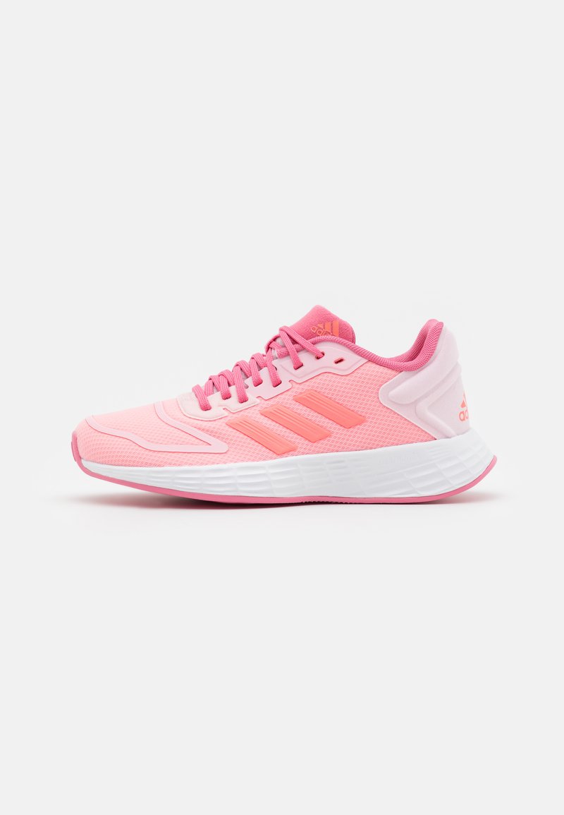 Zapatilla deportiva de color rosa claro con parte superior de malla transpirable, suela blanca y tres rayas de un rosa más oscuro. Presenta un collar acolchado y un diseño de cordones.