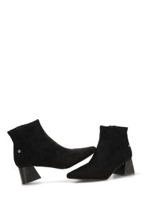 Botines de ante negro con punta afilada, tacones ligeramente altos y adornos decorativos de metal plateado a cada lado. La textura es suave.