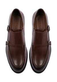 Bruine leren schoenen met een gladde afwerking, voorzien van twee zijklikken en een ronde neus. Het ontwerp heeft een gestructureerde silhoutte en gestikte accenten.