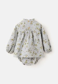 Lasten kukkakuosiset puserot, harmaassa kankaassa keltaisilla ja vihreillä yksityiskohdilla. Puseroissa on pitkät hihat, gathered vyötärö ja nepparit.