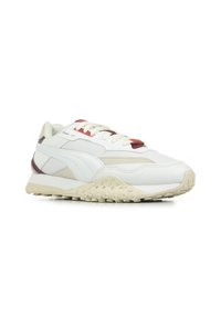 Sneaker bianchi con una tomaia testurizzata, caratterizzati da dettagli rossi e beige, una suola spessa color crema con punte rotonde e un sistema di allacciatura tradizionale.