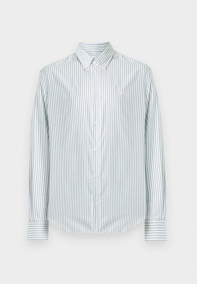 Valge nööpidega pluus, millel on vertikaalsed heledashallid triibud, nööpidega krae ja pikad varrukad triibuliste mansettidega.