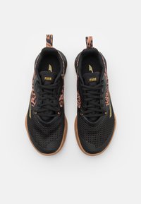 Paar schwarze Sportschuhe mit braun gemusterten Seiten, schwarzen Schnürsenkeln, "FUSE"-Schriftzug auf der Zunge und gummiartigen Sohlen, von oben auf weißem Hintergrund gezeigt.