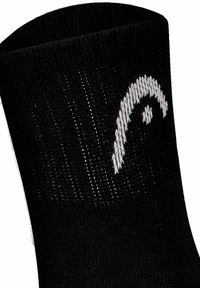 Calcetín negro de punto con una superficie texturada y un diseño de logo blanco cerca del borde superior. El puño es acanalado para un ajuste ceñido.