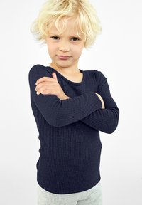 Camiseta de manga larga de canalé azul marino con cuello redondo, llevada por un niño, que presenta un diseño ajustado y una textura suave.