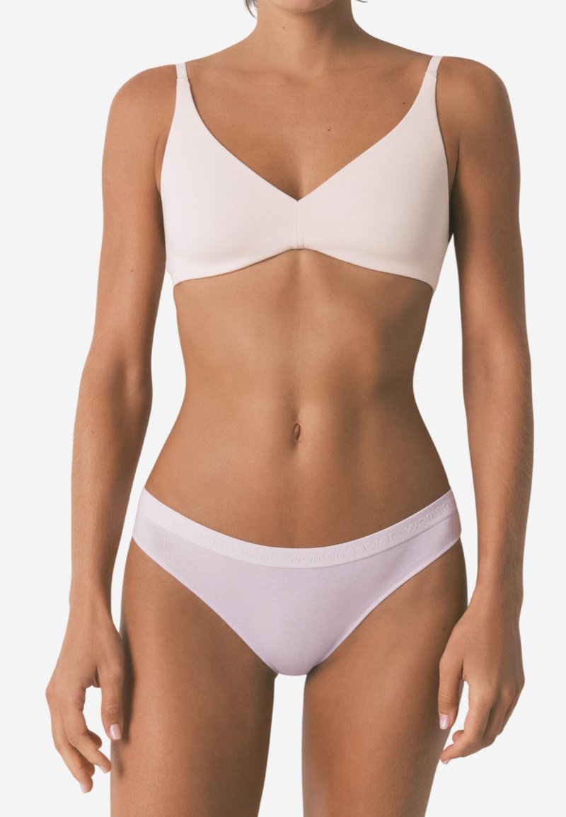 Lichtroze bralette met een V-hals en dunne bandjes; gecombineerd met witte low-rise slips met een subtiele logo op de tailleband. Glad textuur.