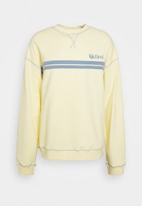Bleekgele sweatshirt met lange mouwen, met blauwe dubbele strepen over de borst en het "Kickers" logo aan de bovenste linkerkant.
