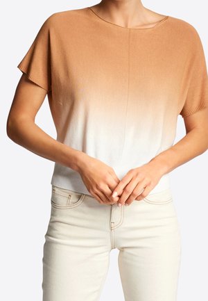 Brązowo-biały ombre krótki sweter z krótkim rękawem, zaokrąglonym dekoltem i ściągaczem na dole, noszony z jasnymi, dopasowanymi jeansami.