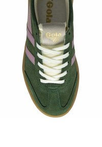 Green suede sneaker with light pink stripes, white laces, and gum outsole. Features a padded tongue labeled with "Gola" in gold.