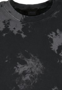 Crna dukserica s uzorkom tie-dye u sivoj boji. Napravljena od mekog materijala s rebrastim okovratnikom i oznakom "URBAN CLASSICS."