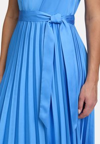 Faltendes blaues Satin-Kleid mit einer gebundenen Taillenschnur, das eine glatte Textur und eine fließende Silhouette präsentiert.