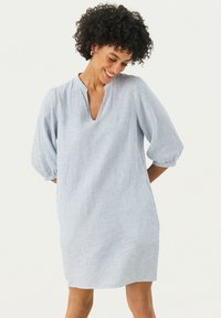 Robe rayée bleue et blanche avec une coupe décontract�ée, décolleté en V et manches bouffantes à mi-longueur, fabriquée en tissu léger.