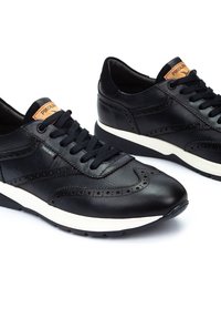 Zapatillas negras de cuero con detalles de brogue, paneles texturizados y una entresuela blanca con suela de goma negra. Incluyen cordones y acentos de logo.