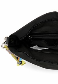 Wnętrze czarnej materiałowej torby z przegrodą na suwak, wieloma kieszeniami oraz odpinanym żółtym paskiem z kolorowymi akcentami.