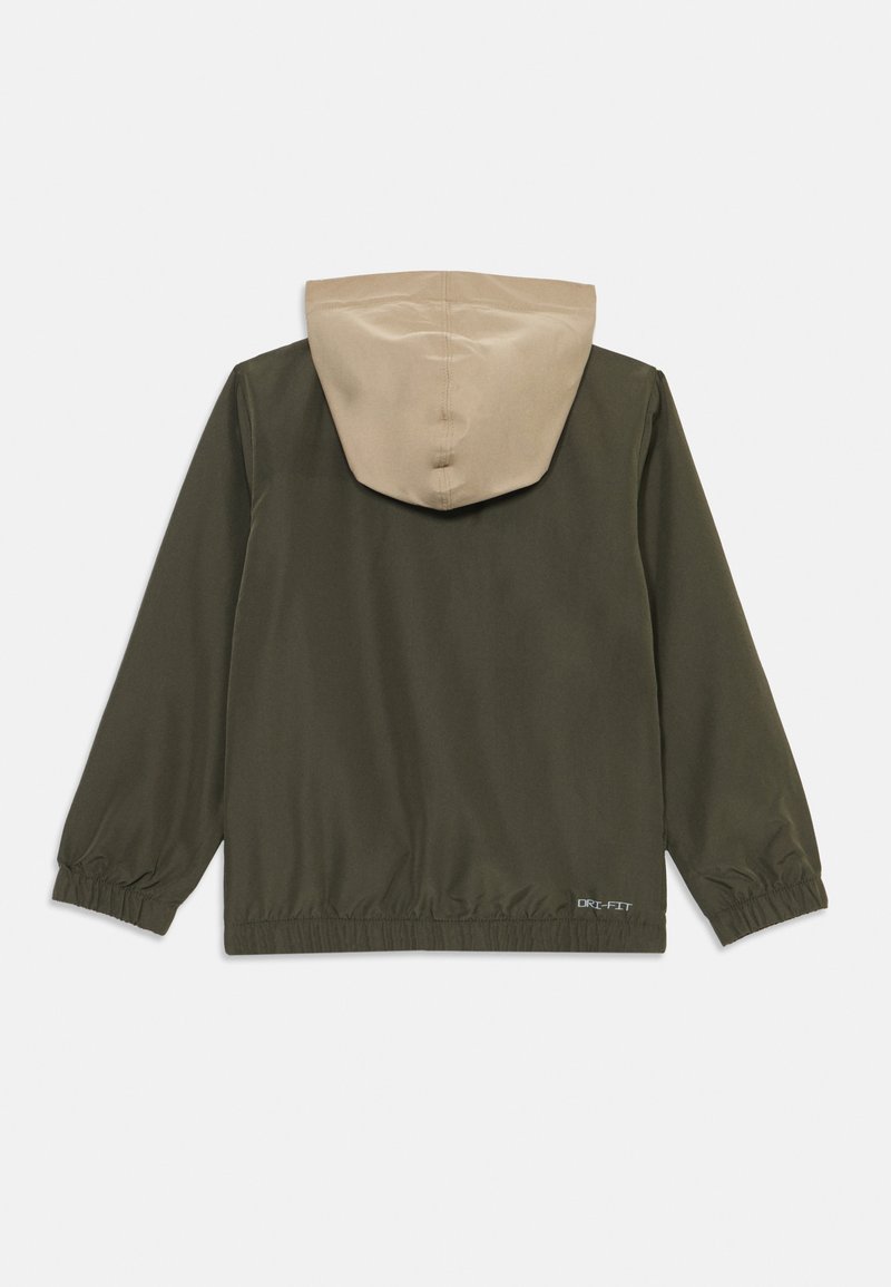 Dunkelgrüne Jacke mit langen Ärmeln, elastischen Bündchen und Saum. Sie verfügt über eine beigen Kapuze und ein "DRI-FIT"-Logo auf der unteren rechten Rückseite.