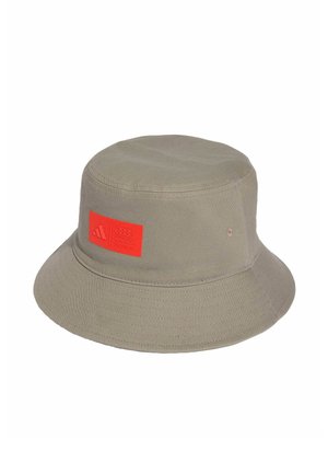 Jasnobrązowy kapelusz typu bucket z szerokim rondem i czerwoną kwadratową naszywką z logo i tekstem z przodu.