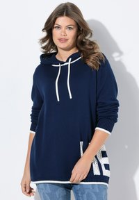Haut à capuche en tricot navy avec des cordons blancs, des poignets et un ourlet côtelés. Détail blanc notable avec un motif "KE" sur le côté. Texture douce.