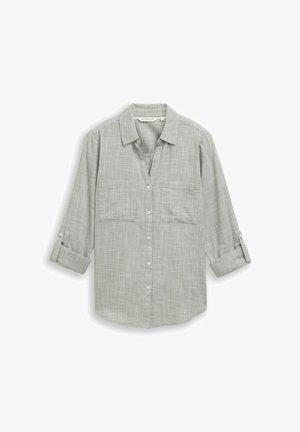 Šedá kostkovaná košile na knoflíky s límečkem, dvěma náprsními kapsami, dlouhými rukávy vyhrnutými nahoru a volným střihem. Vyrobena z lehké látky.