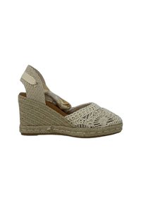 Espadrille de cuña en beige y marrón. Presenta material de yute trenzado, bordado intrincado en la puntera y correa de tobillo ajustable con un patrón a cuadros.