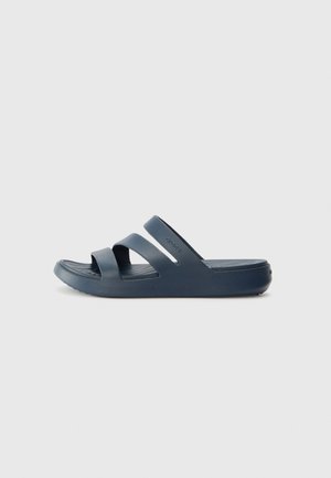 Sandales en caoutchouc de couleur bleu marine, dotées de deux larges bretelles et d'une semelle intérieure anatomique pour le confort. Semelle texturée pour une meilleure adhérence.