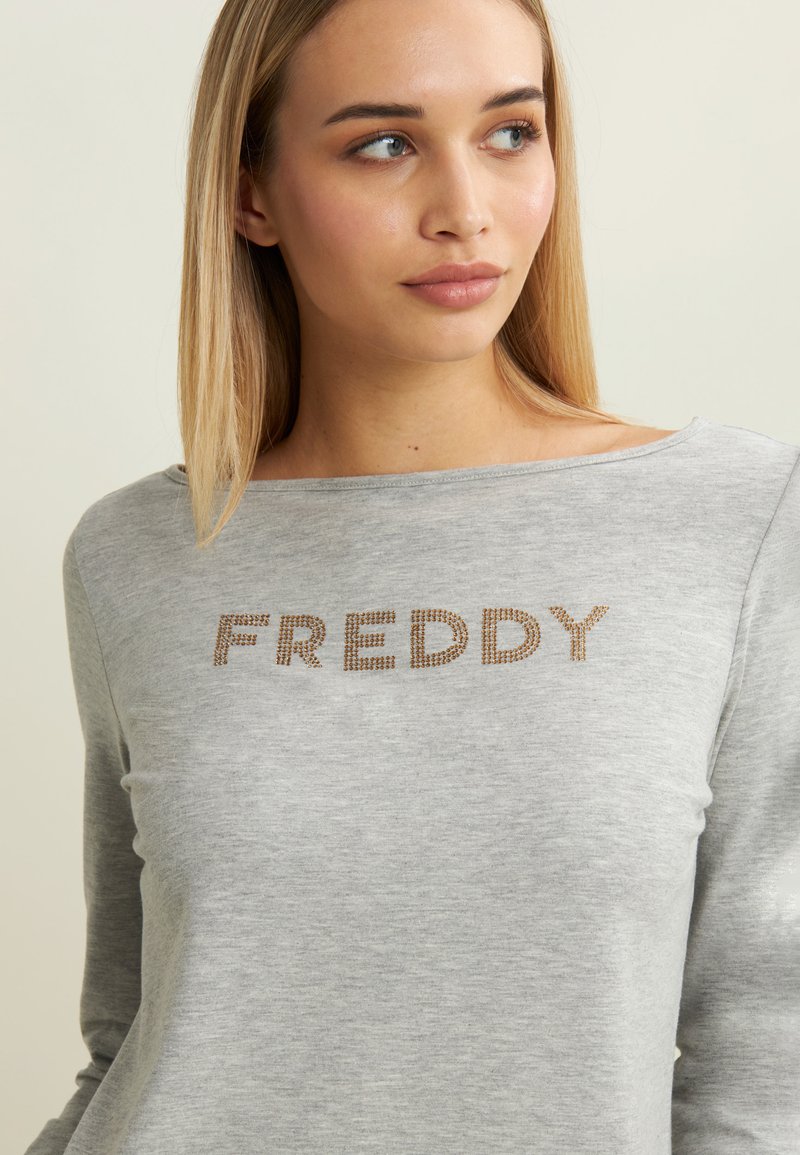 Felpa a maniche lunghe grigia realizzata in tessuto morbido, con la scritta "FREDDY" in caratteri brillanti sul petto e un collo rilassato.