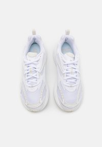 White athletic sneakers feature a mesh upper, lace closure, padded collar, and textured sole with subtle design accents.