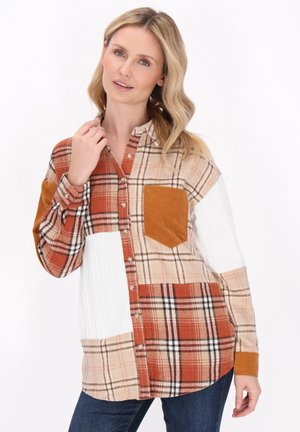 Rutet skjorte med knapper i orange, beige og hvid med patchwork-design. Har en fløjlslomme og teksturerede ærmer.