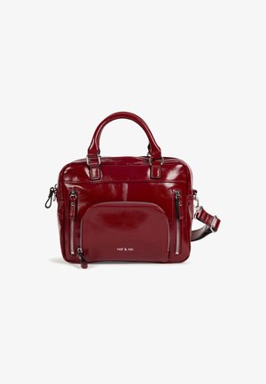 Sac à main en cuir rouge foncé brillant avec deux poignées supérieures, poches zippées à l'avant et une bandoulière réglable sur fond blanc.