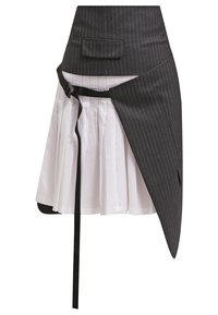 Svart rutigt kjol med ett plisserat vitt innerfoder. Har en sidoknytning och en framficka. Texturerad tyg med kontrasterande färger.