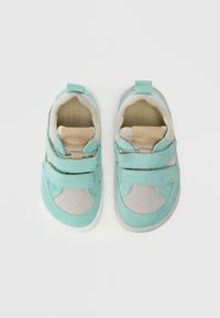 Chaussures turquoise au design en mesh, avec des fermetures à Velcro et une doublure intérieure douce. Elles possèdent une semelle en caoutchouc et des accents beiges pour le contraste.