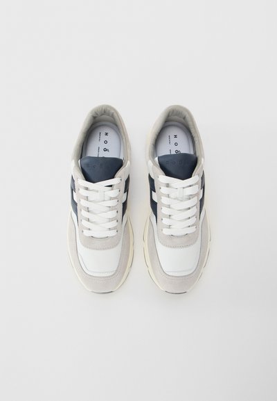 Pair of white and gray sneakers with navy blue accents and white laces, viewed from above on a light background.
