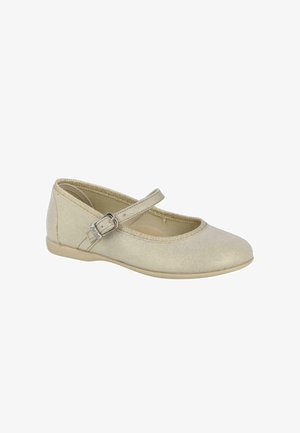 Zapato plano tipo Mary Jane en beige con una única correa ajustable con hebilla y punta redondeada.