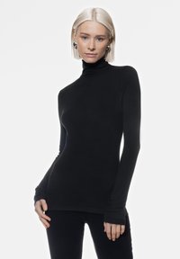 Maglione nero a maniche lunghe con colletto a gong, realizzato in tessuto a costine, con design aderente e aperture per il pollice nei polsini. Texture uniforme.