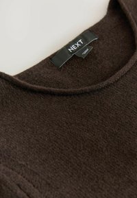 Dunkelbrauner Pullover mit strukturiertem Strick, runden Ausschnitt und einem schwarzen Etikett mit „NEXT“-Markenlogo.