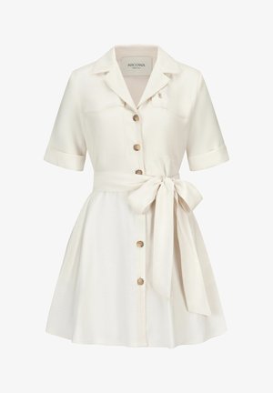 Crèmekleurige jurk met korte mouwen, kraag, knopen aan de voorkant en een gestrikte tailleband, een uitlopende rok en een klein merkembleem op de borst.