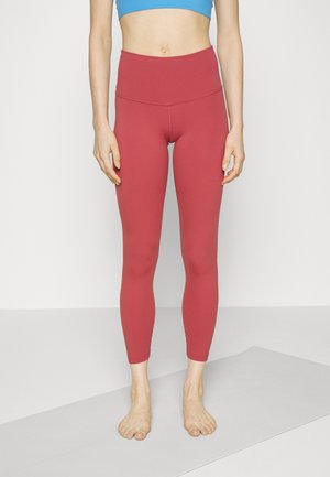 Leggings taille haute, ajustés, de couleur corail rose, fabriqués en tissu extensible, se terminant au milieu du mollet. Ceinture sans couture, texture lisse.