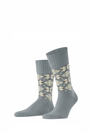 Chaussettes grises avec un motif à flocons de neige de couleur crème et des accents. Poignet côtelé et texture lisse.