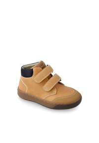 Chaussure montante en suede beige avec deux bandes Velcro, col en maille noire, semelle en caoutchouc marron et coutures blanches pour plus de détails.