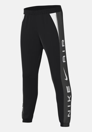 Zwarte sportbroek met een elastische tailleband, zijpanelen in wit en grijs, en grote "NIKE AIR" tekst in het wit gedrukt langs het been.