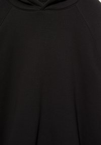 Sweatshirt à capuche noir en tissu doux. Présente des manches raglan et une texture lisse, avec un design simple et minimaliste.