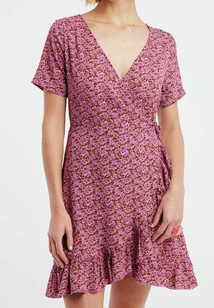 Kurzes, ärmelloses Wickelkleid mit einem pink- und braunfarbenen Blumenmuster, V-Ausschnitt und Rüschensaum. Leichter, weicher Stoff.