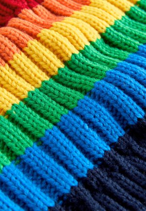 Tkana tkanina z reliefnim vzorcem, razporejena v proge rdeče, oranžne, rumene, zelene, modre in črne barve. Vsak barvni odsek ima izbočene rebraste vzorce.